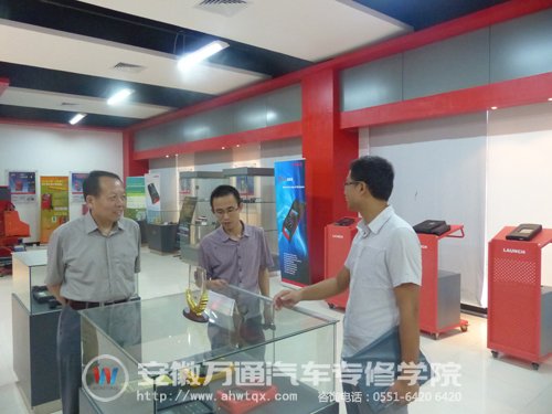 新华教育集团汽修事业部副总经理何扬一行在元征方面陪同下参观企业工作车间